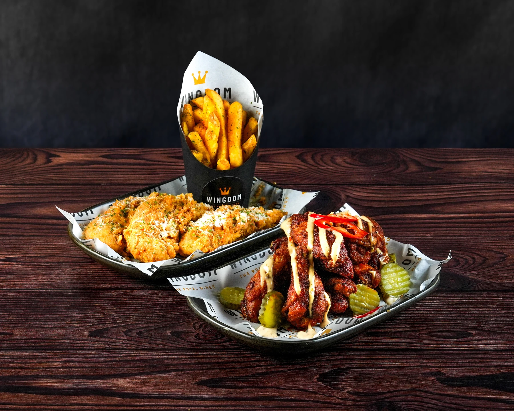 Two trays of Wingdom wings in different flavours with fries